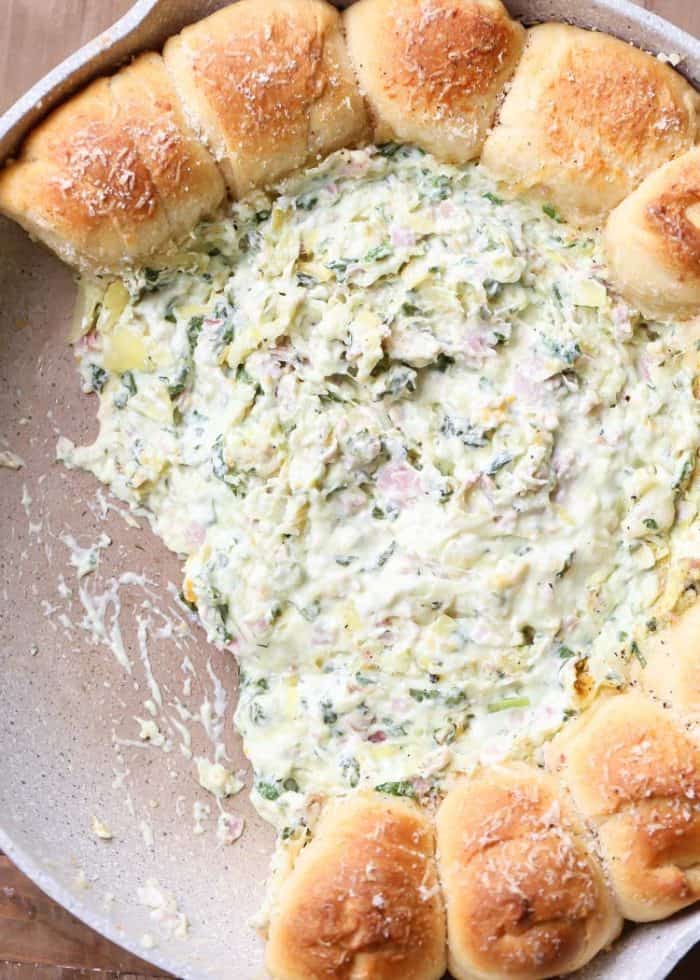 Pull-A-Part crescents with spinach artichoke dip in a skillet with some pieces of bread taken out