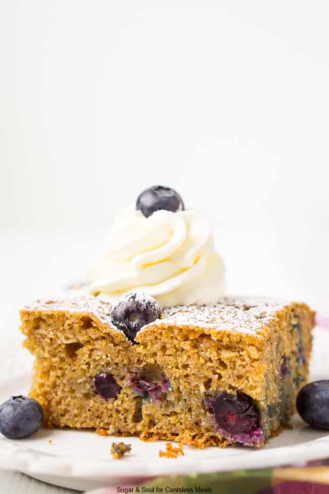 Overnight blueberry coffee cake on a plate with blueberries on the side