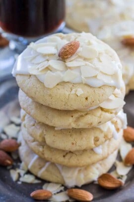 Stack of buttery almond cookies on a plate with almonds as garnish
