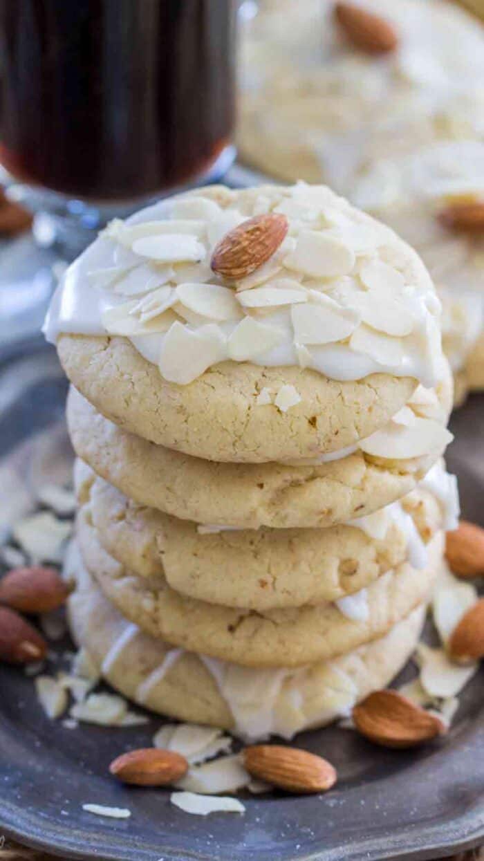 Stack of buttery almond cookies on a plate with almonds as garnish