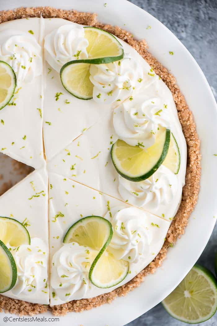 Key lime pie in a pie plate with a piece taken out
