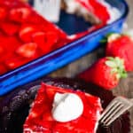 Strawbery Pretzel Salad in a dish and on a plate with whipped cream on top