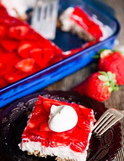 Strawbery Pretzel Salad in a dish and on a plate with whipped cream on top
