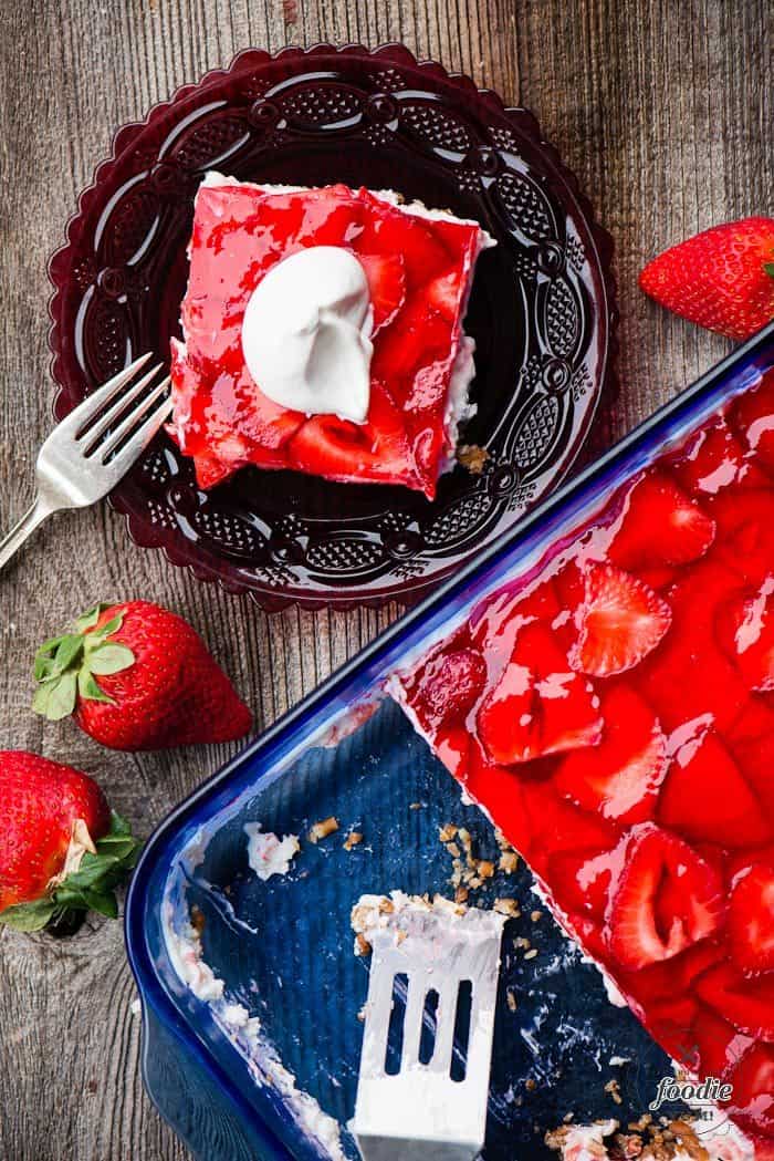 Strawbery Pretzel Salad in a dish and on a plate with strawberries on the side