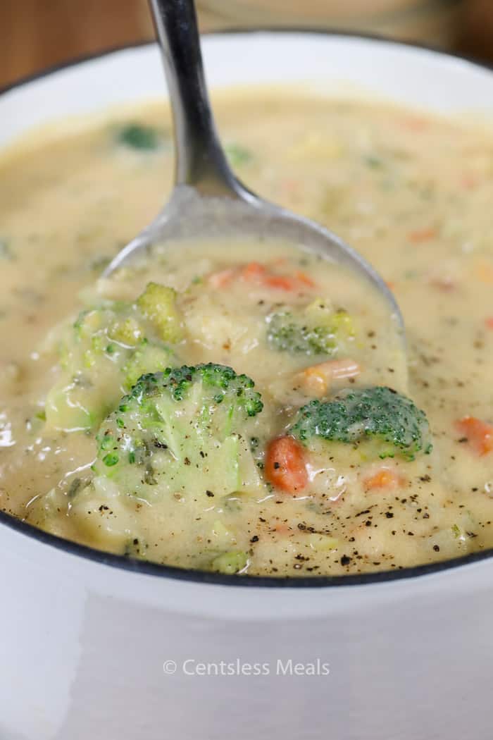 Ham potato soup in a white bowl with a spoonful being taken out