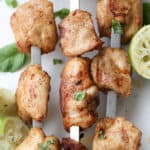 Lime grilled chicken kabobs on skewers with lime as garnish