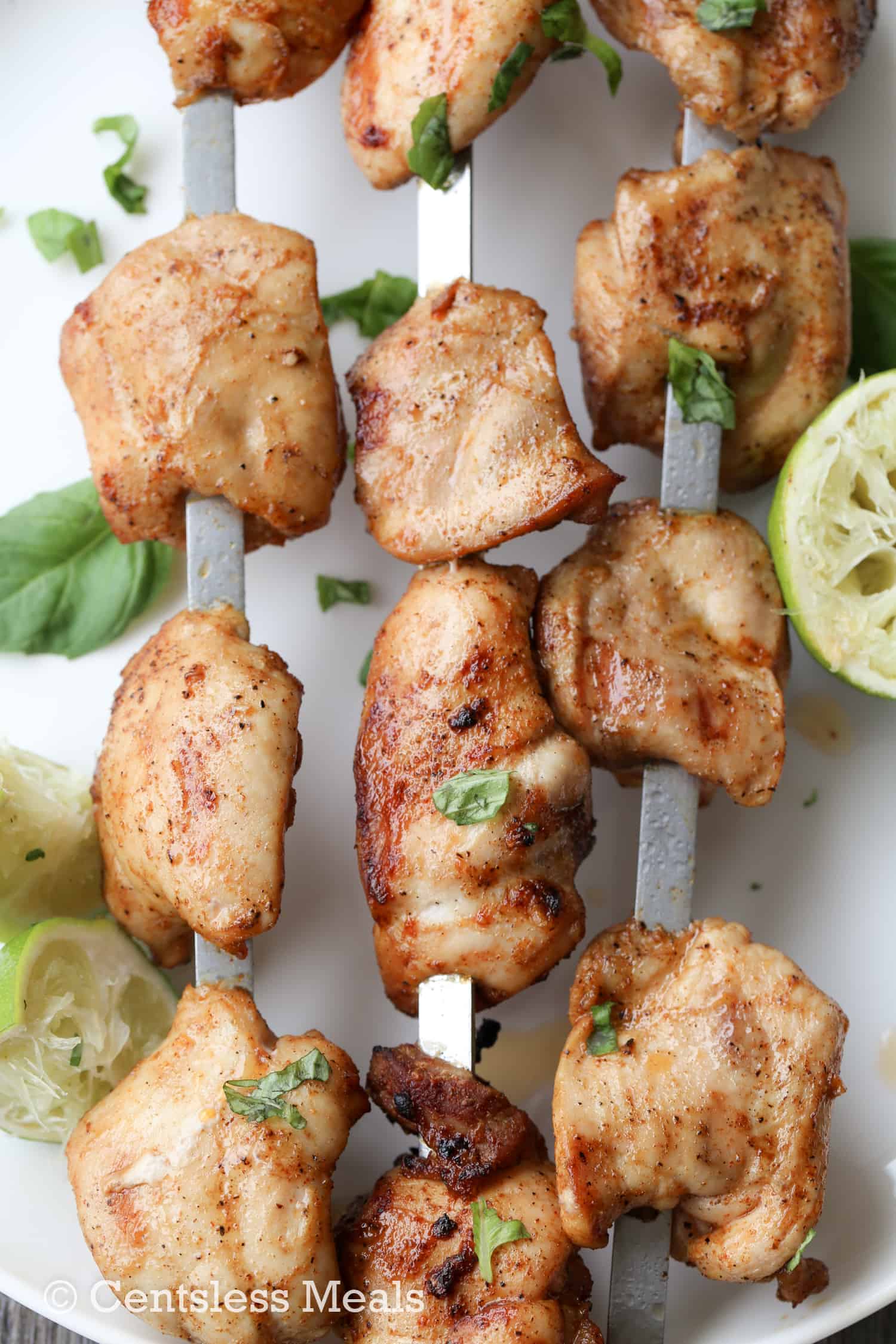 Lime grilled chicken kabobs on skewers with lime as garnish