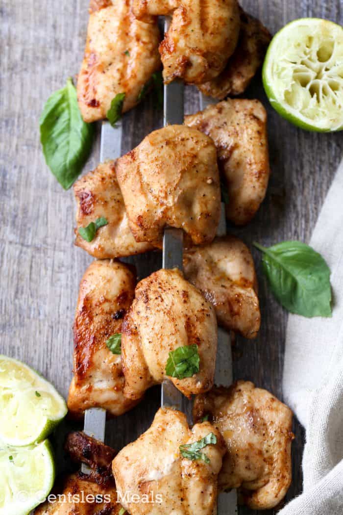 Lime grilled chicken kabobs on a skewer with lime and cilantro