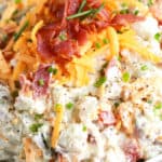 Potato salad in a bowl with bacon and cheese