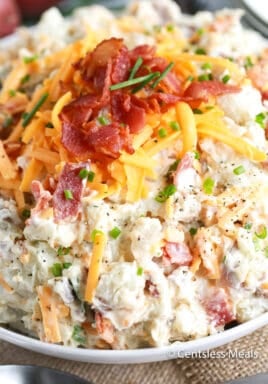 Potato salad in a bowl with bacon and cheese