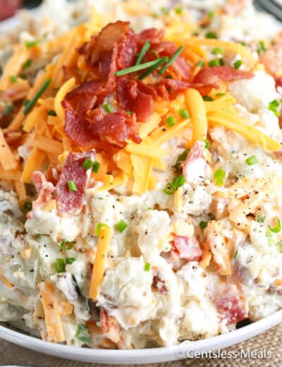 Potato salad in a bowl with bacon and cheese