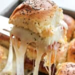 Italian Sliders in a pan with one being pulled out to show the melted cheese