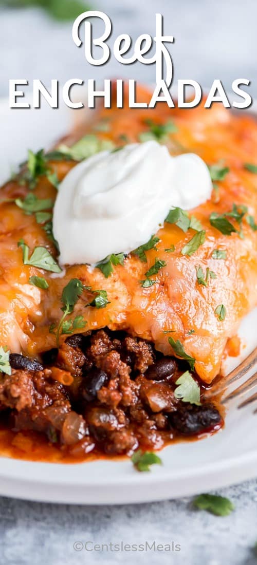 Beef enchiladas on a plate with sour cream and a title