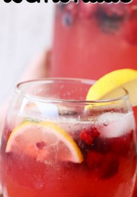 Berry lemonade in a glass with berries and lemon with a title