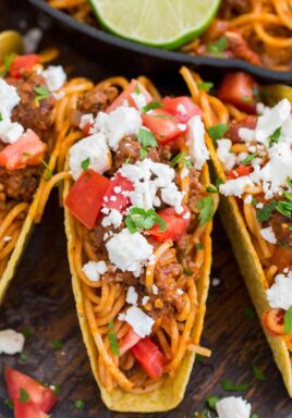 Spaghetti Tacos are messy, fun and extra delicious. Cooked in a rich beef and tomato sauce and served in crispy taco shells with your favorite toppings.