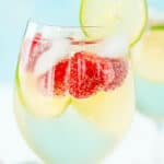 Raspberry lime wine spritzer with berries and lime as garnish