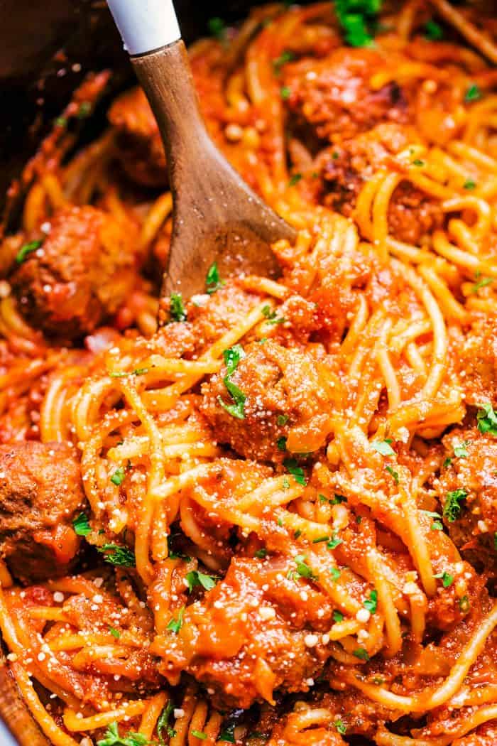 Crock-Pot spaghetti and meatballs in a crock pot with a wooden spoon