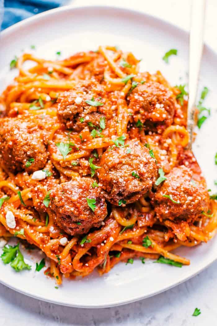 Crock-Pot spaghetti and meatballs on a white plate with a fork
