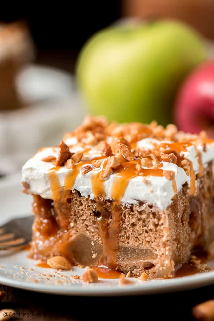 Caramel apple poke cake drizzled with caramel on a white plate