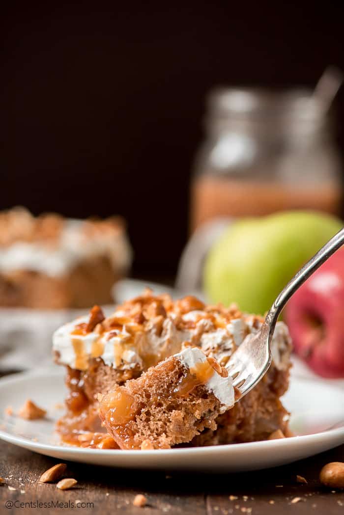 Caramel apple poke cake on a plate with a bite on a fork