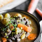 instant pot beef stew in a bowl garnished with thyme