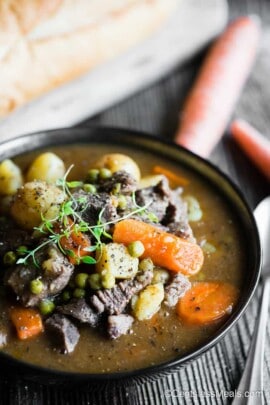 instant pot beef stew in a bowl garnished with thyme