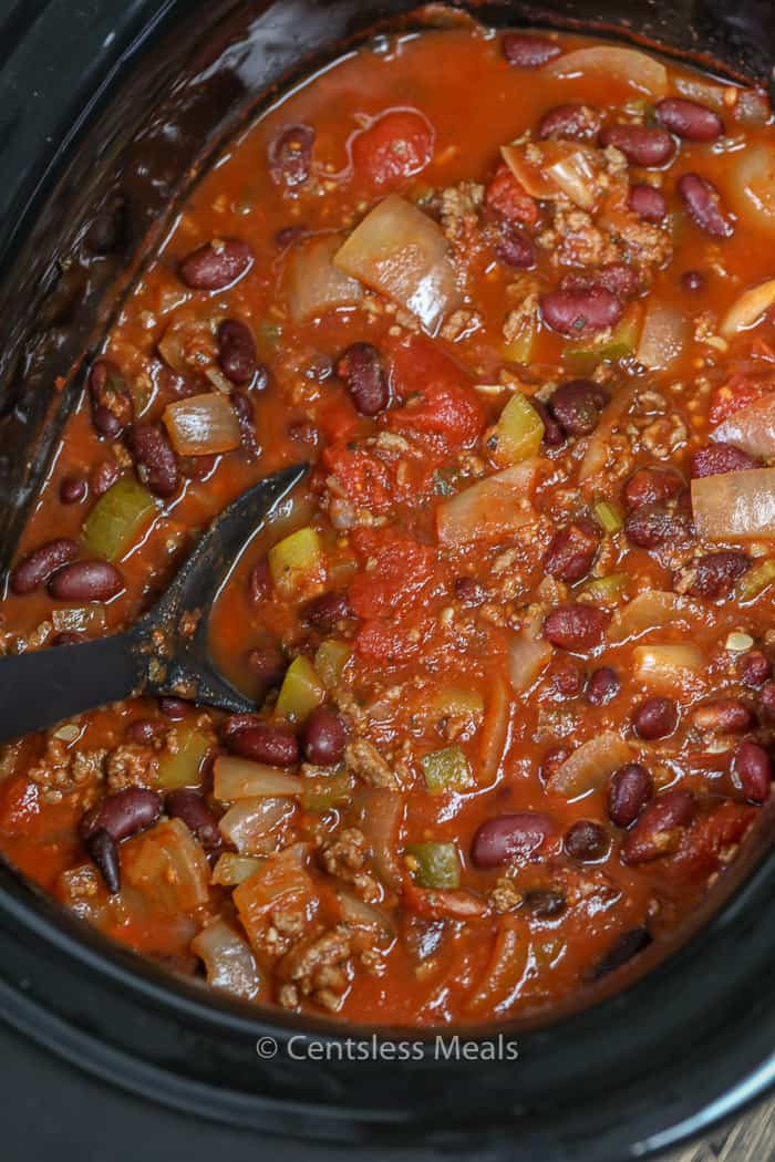 Crockpot chili in a Crock-Pot with a black spoon