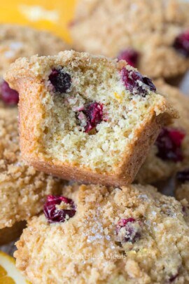 Cranberry orange muffins with a bite taken out of one to show the inside