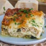 Chicken alfredo lasagna on a blue plate garnished with parsley