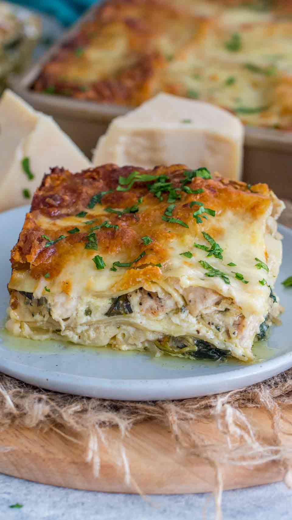 Chicken alfredo lasagna on a blue plate garnished with parsley