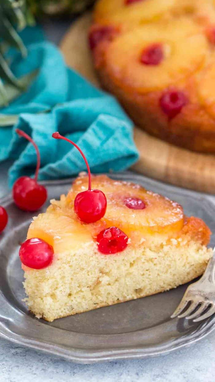 A piece of pineapple upside down cake on a plate with a fork