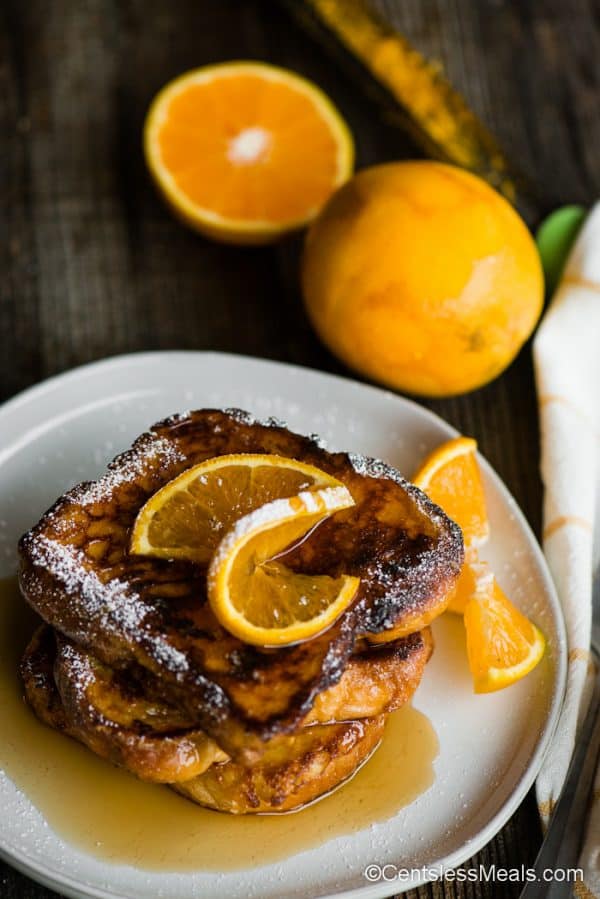 grand marnier french toast on a white plate with orange slices