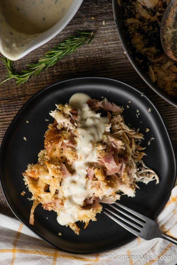 serving of chicken cordon bleu casserole with cream sauce on a plate with a fork