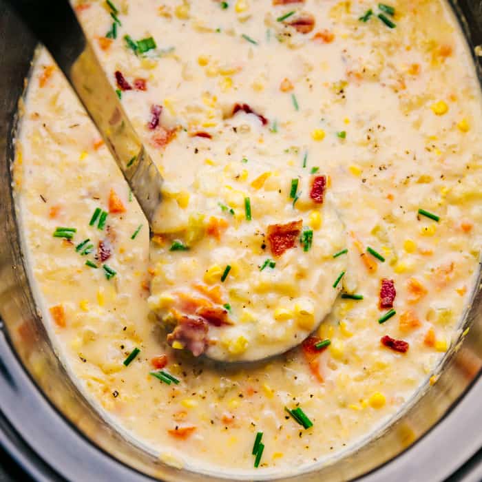 Crock-Pot corn chowder in a crock pot with a scoop being taken out