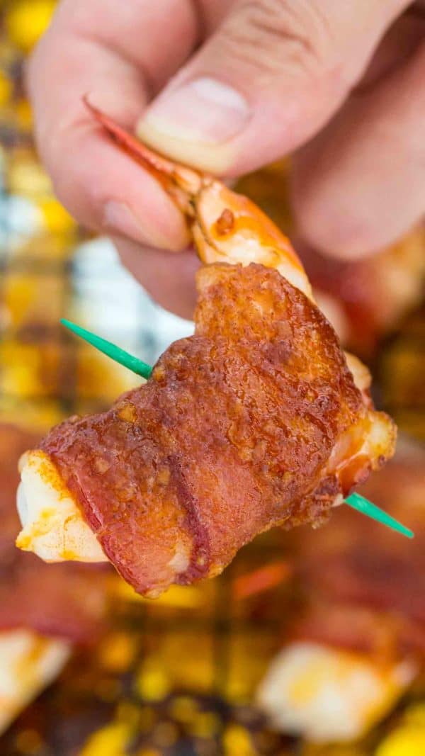 Bacon wrapped shrimp picked up with a hand