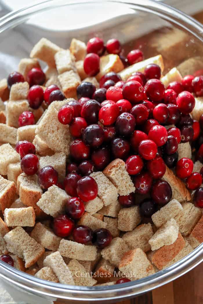 Ingredients for cranberry bread pudding in a glass bowl