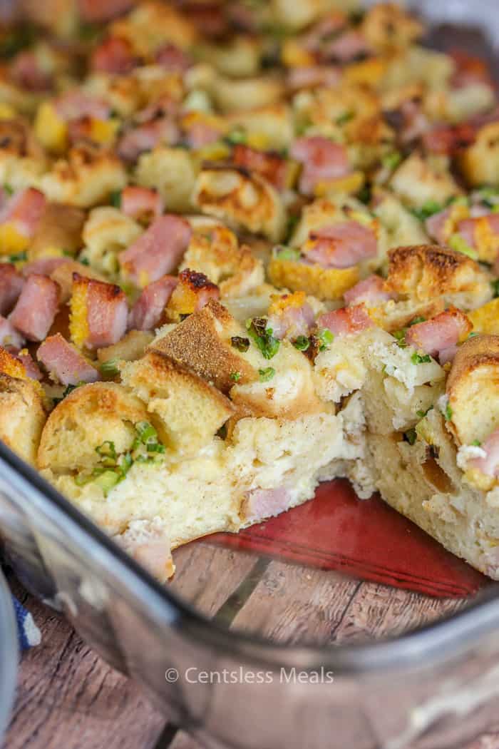 Eggs benedict casserole in a casserole dish with a piece taken out
