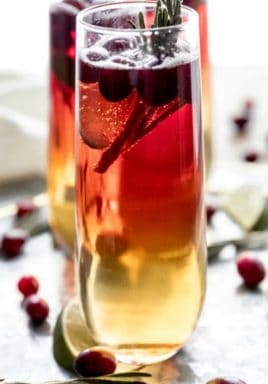 Cranberry champagne cocktail in a glass with a title