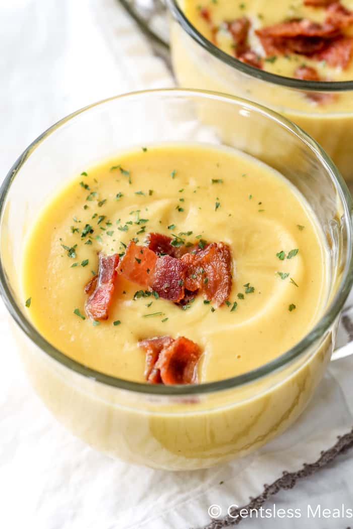 overhead of Squash Soup in a glass bowl with bacon garnish