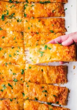 Cheesy breadsticks with one being pulled apart