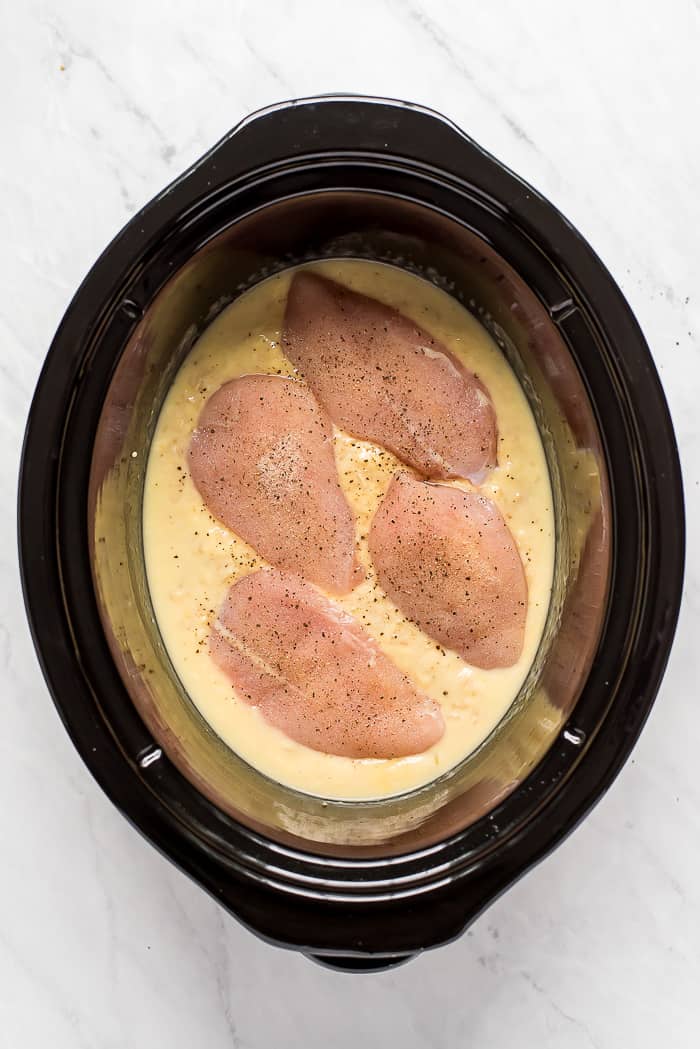 Raw chicken with sauce in a crock pot