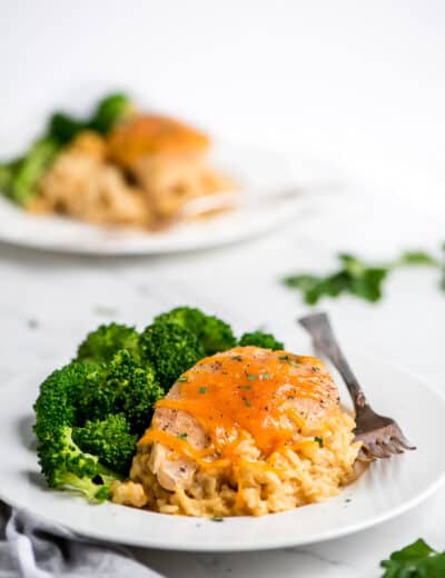 Crock-Pot Crock-Pot cheesy chicken rice on a white plate with broccoli and a fork