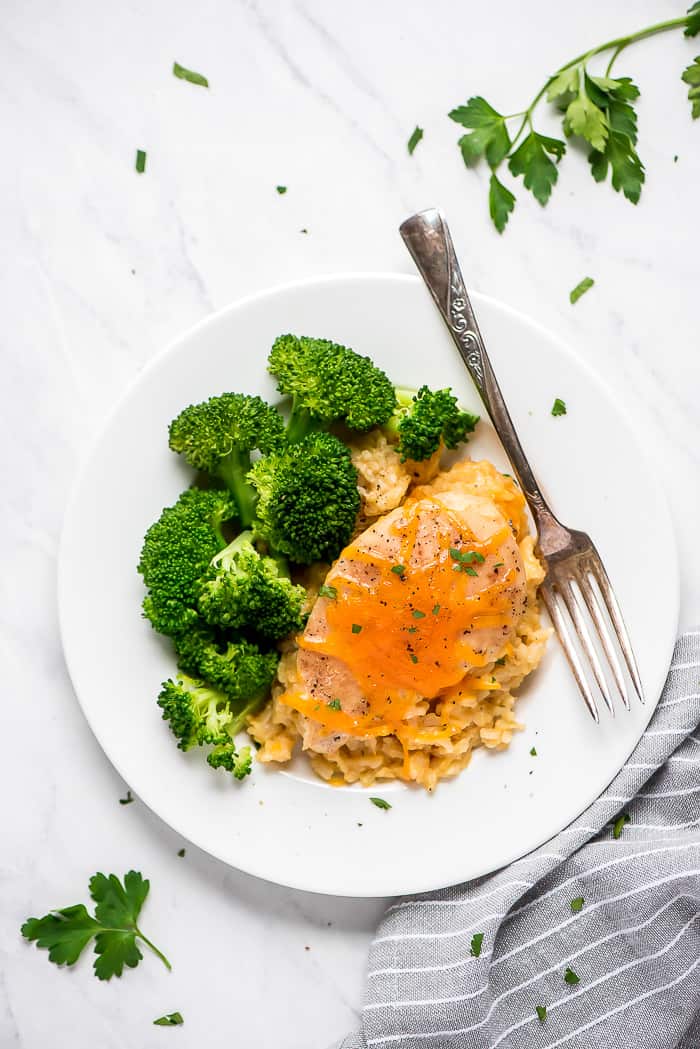 Crock-Pot cheesy chicken rice on a plate with a fork and broccoli