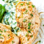 Spinach stuffed chicken on a plate garnished with parsley and Seasonings