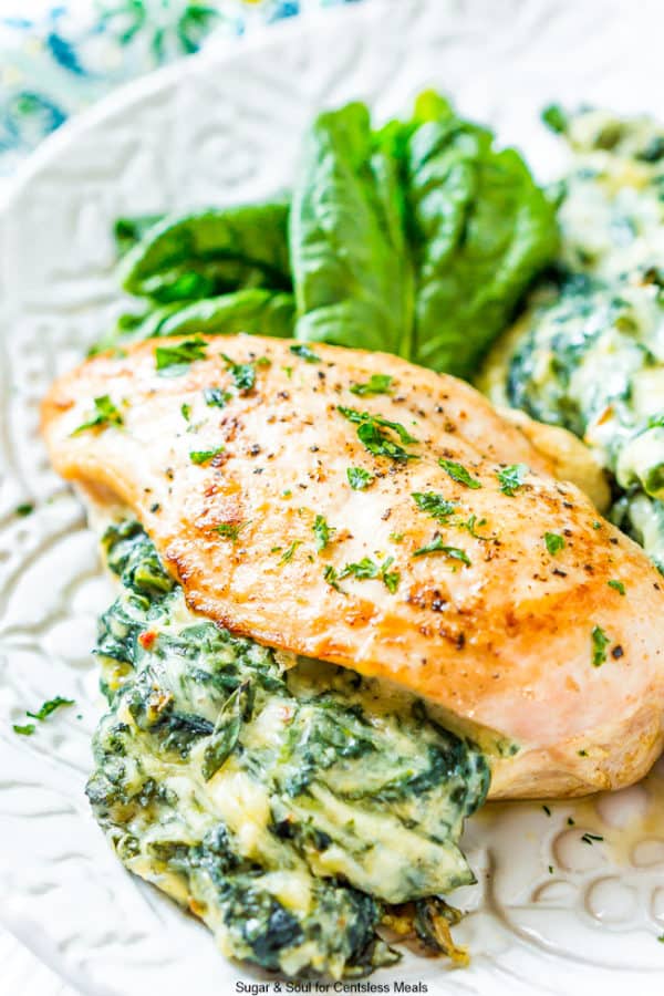 Spinach stuffed chicken on a plate garnished with parsley