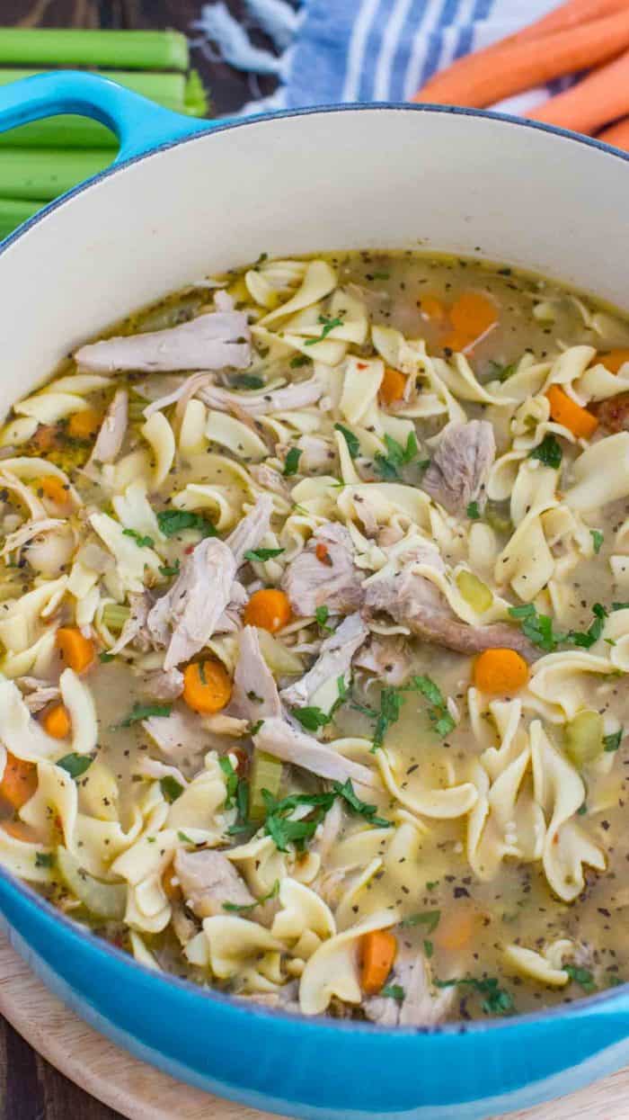 Homemade Chicken Noodle Soup in a blue pot garnished with parsley