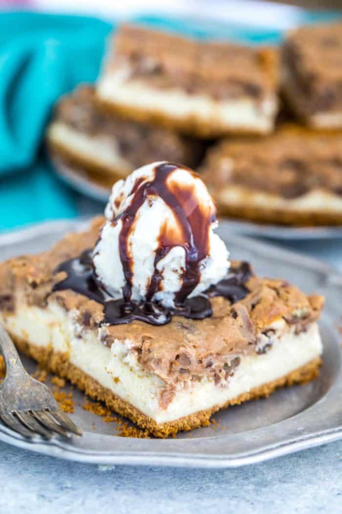Pecan pie cheesecake on a plate topped with ice cream and chocolate sauce