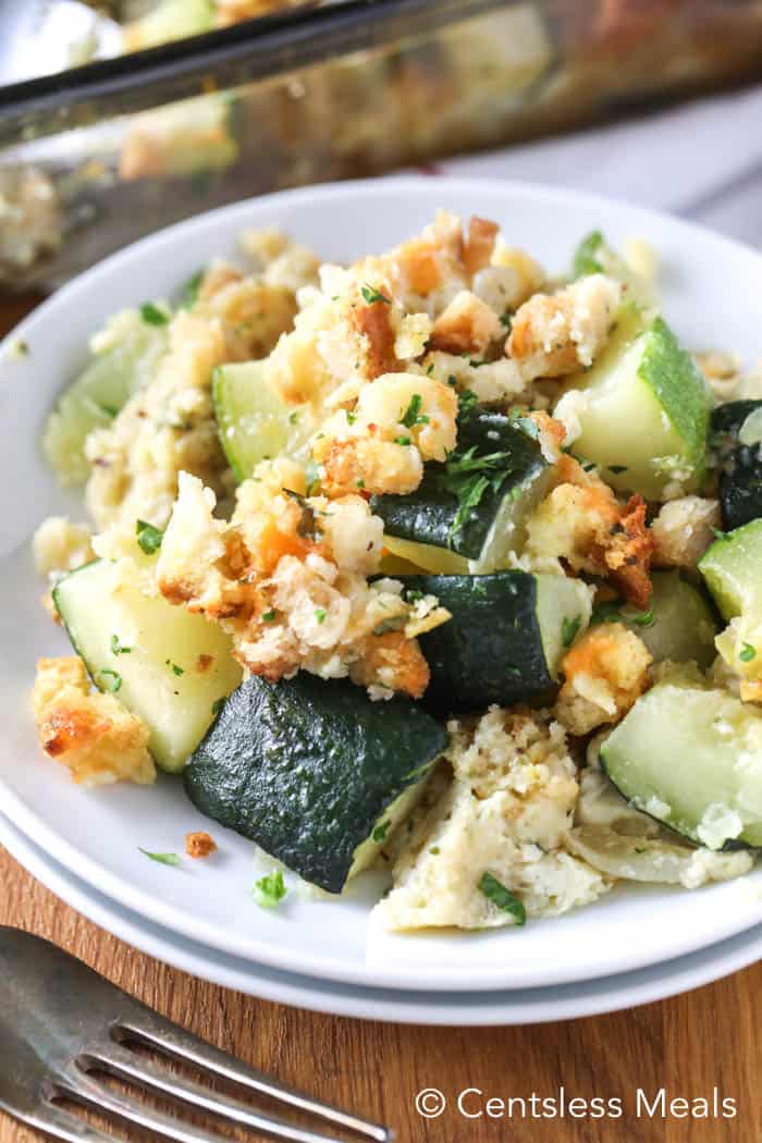 Zucchini casserole on a white plate garnish with parsley