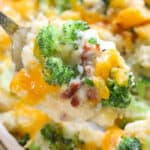 Broccoli potato casserole in a dish with a scoop on a spoon