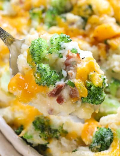 Broccoli potato casserole in a dish with a scoop on a spoon